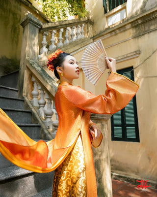 Mẫu áo dài cách tân Thạch Vân họa tiết hoa trên nền cam bởi La Hằng